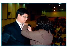 Fotografia de Vinicius Lameira Bernardo recebendo a insígnia institucional do MPRJ