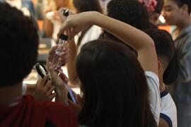 Fotografia dos estudantes da CIEP Dr. Ernesto Che Guevara enquanto observam os insetos em tubos d...
