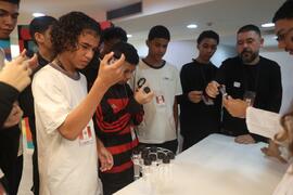 Fotografia dos estudantes da EM General Tasso Fragoso enquanto observam os insetos no tubo de ensaio