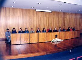 Fotografia dos participantes da mesa diretora durante a realização de uma reunião