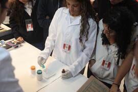 Fotografia de uma estudante da EM José de Alencar enquanto higieniza a moeda