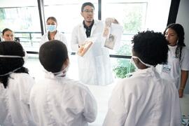 Fotografia de Kevyn Gonçalves mostrando os documentos acondicionados pelos estudantes da Escola M...