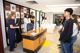 Fotografia de Patricia Leite Carvão mostrando a beca de Procurador de Justiça aos alunos do Ginás...