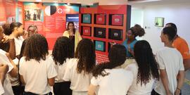 Fotografia de Samara Tarouquela e de Nayara dos Santos junto aos estudantes do Ginásio Educaciona...