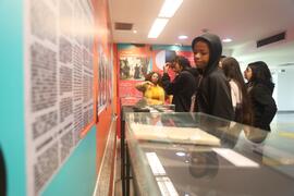 Fotografia dos estudantes da EM General Tasso Fragoso observando os itens do acervo