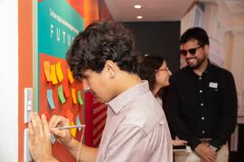 Fotografia do visitante Kauã Rangel deixando uma mensagem no painel "Um Olhar Para o Futuro&...