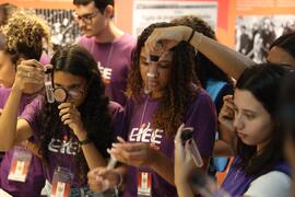 Fotografia dos jovens aprendizes do CIEE enquanto observam os insetos em tubos de ensaio