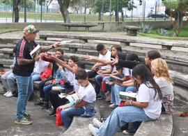 Fotografia dos estudantes do CIEP Dr. Ernesto Che Guevara junto ao historiador do MHN