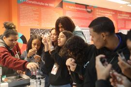 Fotografia dos estudantes do CE Missionário Mário Way enquanto observam os insetos no tubo de ensaio